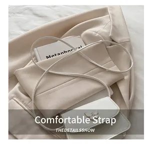 Close-up of white leather square crossbody bag with elegant butterfly embellishment