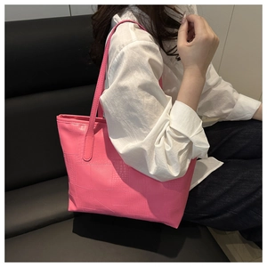 Detail of pink tote bag with geometric crocodile texture and slim shoulder straps