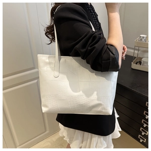 White large tote bag with crocodile pattern texture shown on model's shoulder style