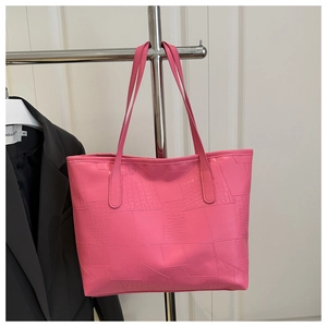 Close-up of rose pink tote bag with crocodile embossed texture and slender straps