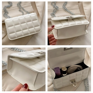 Detail view of white quilted chain bag showing interior capacity and silver metal hardware