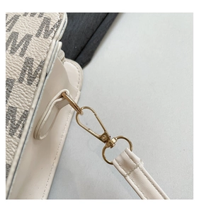 Detailed close-up of light gold hardware and pebble texture on cream white crossbody bag