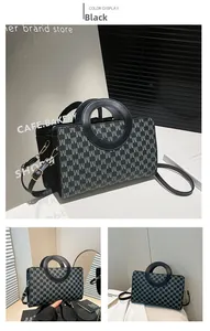 Detail view of the black crossbody bag showing M-letter monogram and round handle