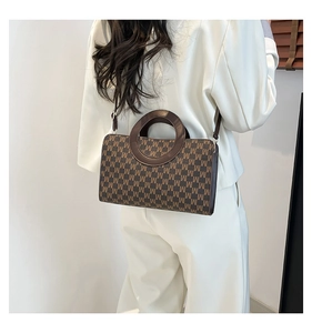 Detail of vintage tote bag with M-letter pattern and unique round resin handle on model