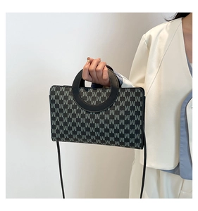 Detail of retro M-letter monogram handbag with unique circular cutout handle