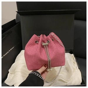 Detailed view of pink corduroy bucket bag featuring pearl charms and silver chain strap