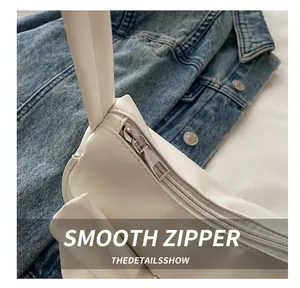 Detail showing smooth metal zipper on white bow shoulder bag with fine PU leather texture