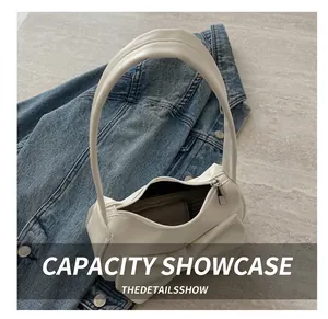 Internal view of a white leather underarm bag showing interior capacity and zipper detail