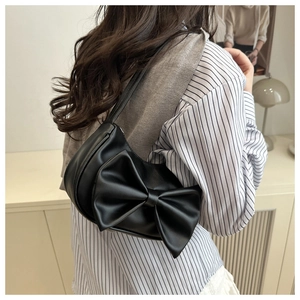 Detail of elegant black PU leather hobo bag featuring a large decorative bow on the shoulder