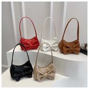 Close-up of five stylish faux leather bags with large bow accents in assorted colors