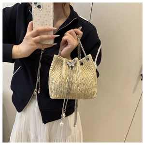 Chic beige woven bucket bag with silver butterfly clasp and pearl chain strap
