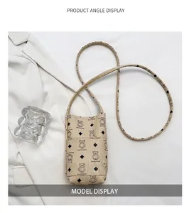 Detail view of beige crossbody phone bag with bear print and stylish leather strap