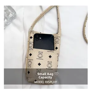 Internal view showing small crossbody bag capacity with a smartphone inside