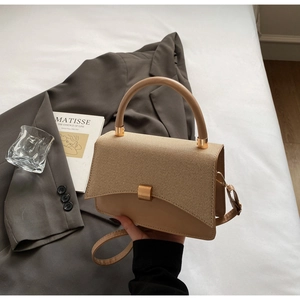 Detail of the woven texture flap and smooth khaki leather on this elegant crossbody bag