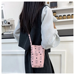 Pink PU leather crossbody bag featuring bear prints and a slim shoulder strap on model