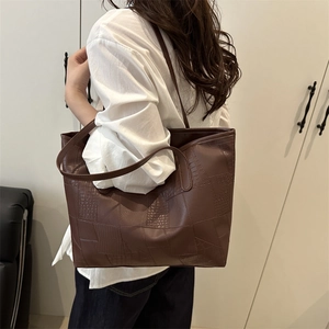 Retro chocolate brown large tote bag with crocodile texture worn on shoulder for commute