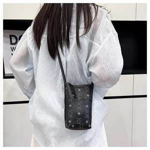 Detailed view of black leather mini bucket bag featuring silver cartoon bear patterns