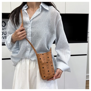Detail of a mini brown leather crossbody bucket bag featuring a cute bear and diamond print
