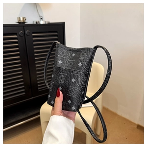 Detail of mini black crossbody phone bag featuring cartoon bear and geometric patterns