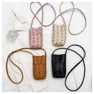 Detailed flat lay of four colorful mini crossbody phone bags with bear prints and leather texture