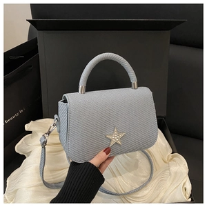Detail of light blue textured handbag with rhinestone star in a premium gift box set