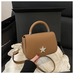 Detail view of a brown woven texture mini bag with a sparkling rhinestone star on the flap