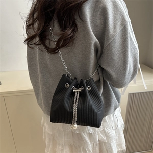 Fashionable black corduroy bucket bag with pearl drawstring and silver chain strap
