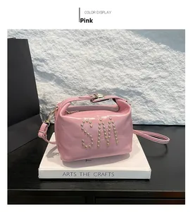 Sac bandoulière en cuir verni rose avec logo SM clouté doré et fermoir rotatif