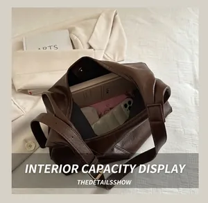 Macro view of spacious interior of brown leather tote bag showing items and books