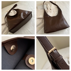 Detail view of dark brown leather tote bag with magnetic closure and adjustable strap buckle