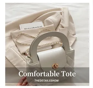 Detailed close-up of white quilted leather handbag with gold turn-lock and chain strap