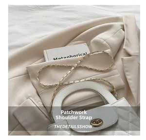 Close-up of white quilted bag featuring a golden twist lock and chain strap detail
