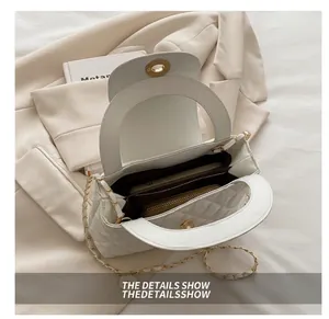Top view of open white quilted handbag showing internal storage capacity on a suit