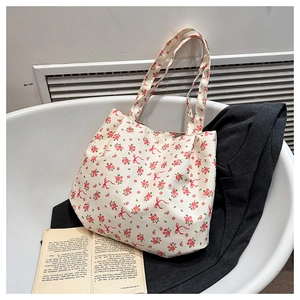 Dettaglio della borsa tote in tela floreale con rose rosse e ampi spallacci