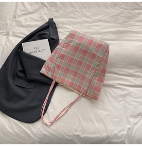 Détail d'un sac cabas en toile à carreaux rose et vert avec fine bandoulière élégante
