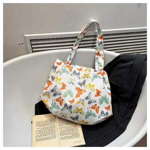 Dettaglio della borsa tote in tela bianca con stampe di farfalle colorate in set lifestyle