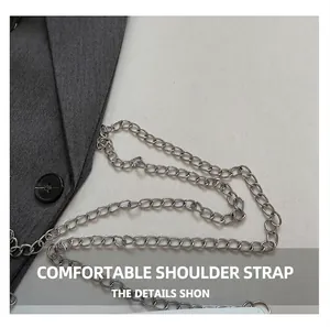 Detailed close-up of a silver metal chain strap on a minimalist crossbody bag texture