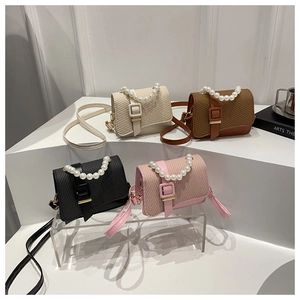 Mini crossbody bags in four colors with pearl handles and woven texture on white steps