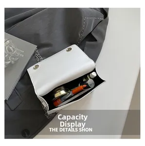 Internal view of a minimalist white chain bag showing storage for phone and makeup