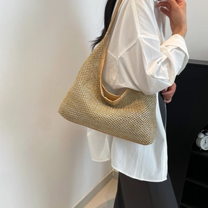 Chic woven hobo bag with brown leather trim shown in a minimalist lifestyle setting