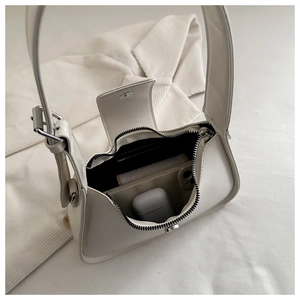 Detailed view of cream PU leather shoulder bag showing interior space for phone and earbuds