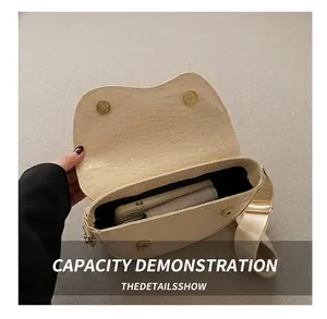Detail view of cream saddle bag with crocodile texture showing interior storage capacity