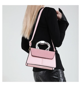 Rosafarbene Tasche im Detail mit gewebter Klappe und silbernem Metallgriff