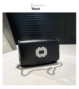 Detail of the sparkling rhinestone square buckle and black glossy leather on chain bag