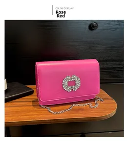 Detail of rose red leather bag featuring a sparkling crystal buckle and silver chain