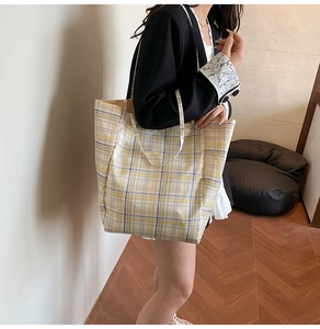 Détail du grand sac cabas en nylon à carreaux jaunes et gris avec des anses de transport