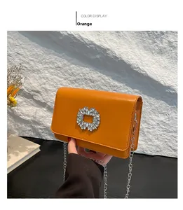 Detail of orange-brown leather crossbody bag with sparkling square rhinestone buckle
