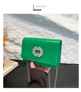 Detailed view of emerald green leather bag with silver chain and rhinestone buckle