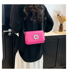 Detail of rose pink patent leather bag with a sparkling diamond-encrusted square buckle