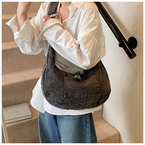 Side view of model wearing a large gray denim hobo bag in a casual lifestyle setting